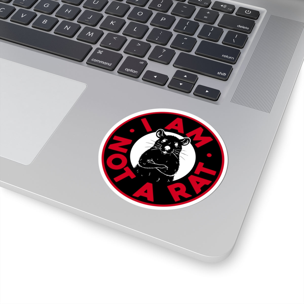 Laptop with a 'I AM NOT A RAT' sticker on the palm rest area